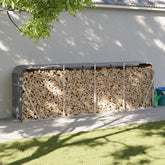 Anthracite galvanized steel log holder with firewood stacked inside, against a white wall outdoors.